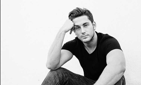 Brent Antonello in black t-shirt and black jeans poses for a photoshoot.